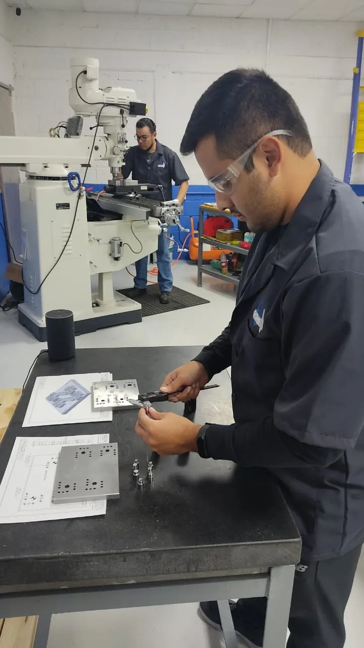 Técnico midiendo una pieza en mesa de inspección